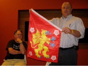 John Niggley shows the Östergötland banner of arms while Mike Hale looks on.