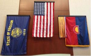 The flags of the State of Oregon, the United States (48 stars, 1912-1959), and the 41st Infantry Division, with battle streamers, decorate the gymnasium foyer at Camp Withycombe, the Oregon National Guard base.