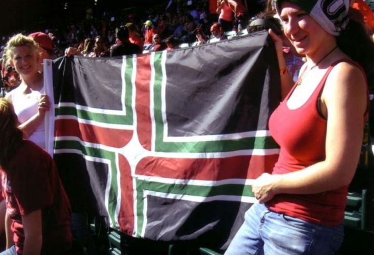 Fans of the Portland Thorns women's soccer team have created a version of the Portland flag, using the team colors of red, green, and black.  They told photographer David Ferriday that the artwork is on file at Elmer's Flag & Banner.