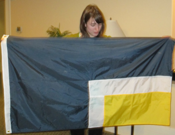 Becky Olson shows her own creation, a flag representing the warmth of Carl Larson’s house in winter. 