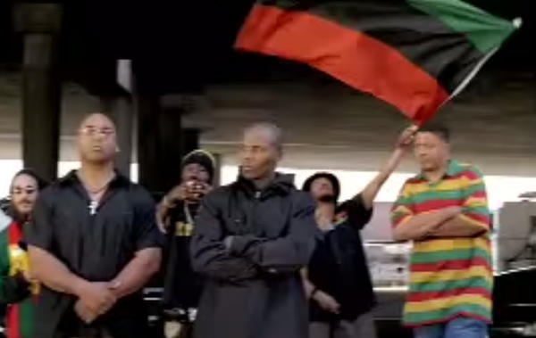 Waved in the background: the red, black, and green Pan-African flag.