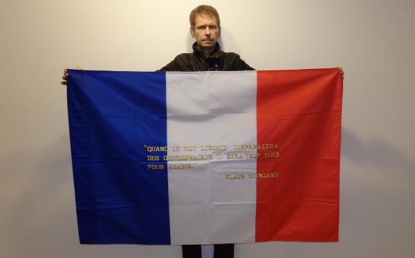 "Klaus Guingand and his flag with the sentence in French"