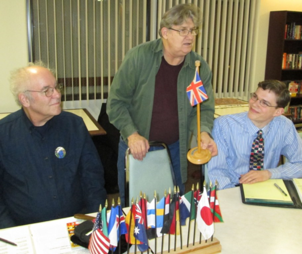 Host Patrick Genna shares a recent Goodwill acquisition as Michael Orelove and Max Liberman (wearing flag tie) look on.