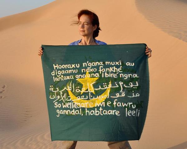 "Isabel Fiadeiro and her flag with the sentence in Pulaar, Arabic and Wolof."
