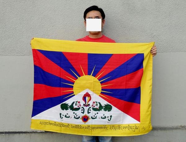 "Tenzin Tondup and his flag with the sentence in Tibetan." (Tondup is a refugee in Nepal.)
