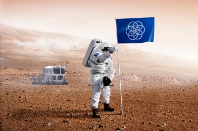 A Mars explorer drives out into a shallow valley, inexplicably, to plant a plastic looking banner/flag.