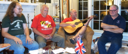 Casey Sims sings a song inspired by his new personal flag, enjoyed by Robert Izatt, Ken Dale, and Dennis Stephens.