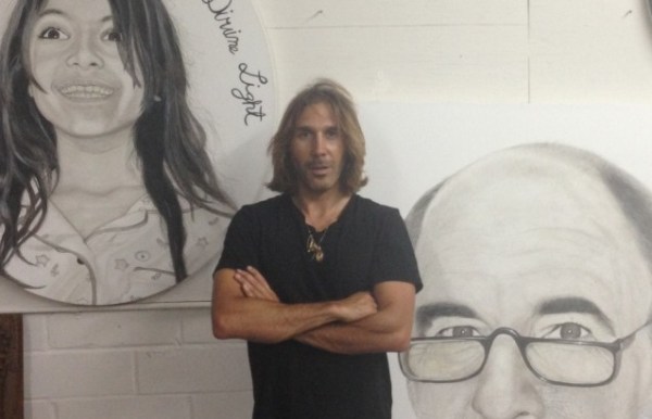 Nimai Kesten in front of some of his portraits, August 2013.  Photo from the Art Nerd Los Angeles blog.