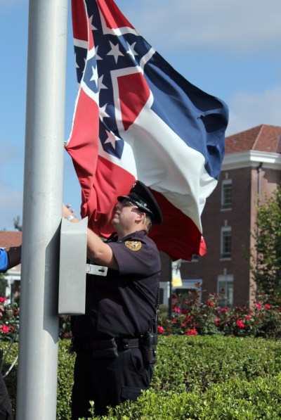 An SMU police officer takes down the state flag, 28 October 2015. Photo by Brittany Stewart, Student Printz.