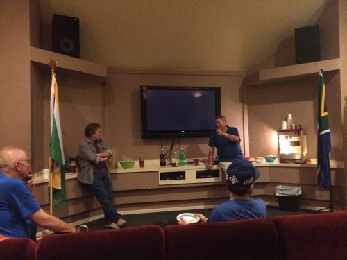 Jerry Fest (left) and Larry Snyder (right) talk flags as Michael Orelove (left) and Fred Paltridge (center) look on. The flags are those of the Portland Flag Association (left) and South Africa (right).