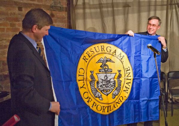 Portland City Councilor Ed Suslovic presenting the flag of the City of Portland